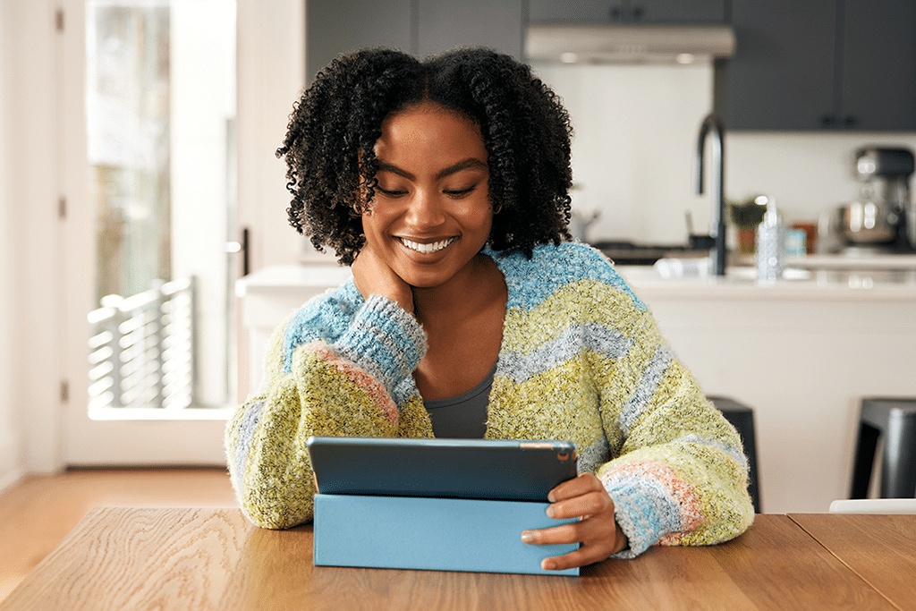 Girl watching Tablo on her tablet in the kitchen.