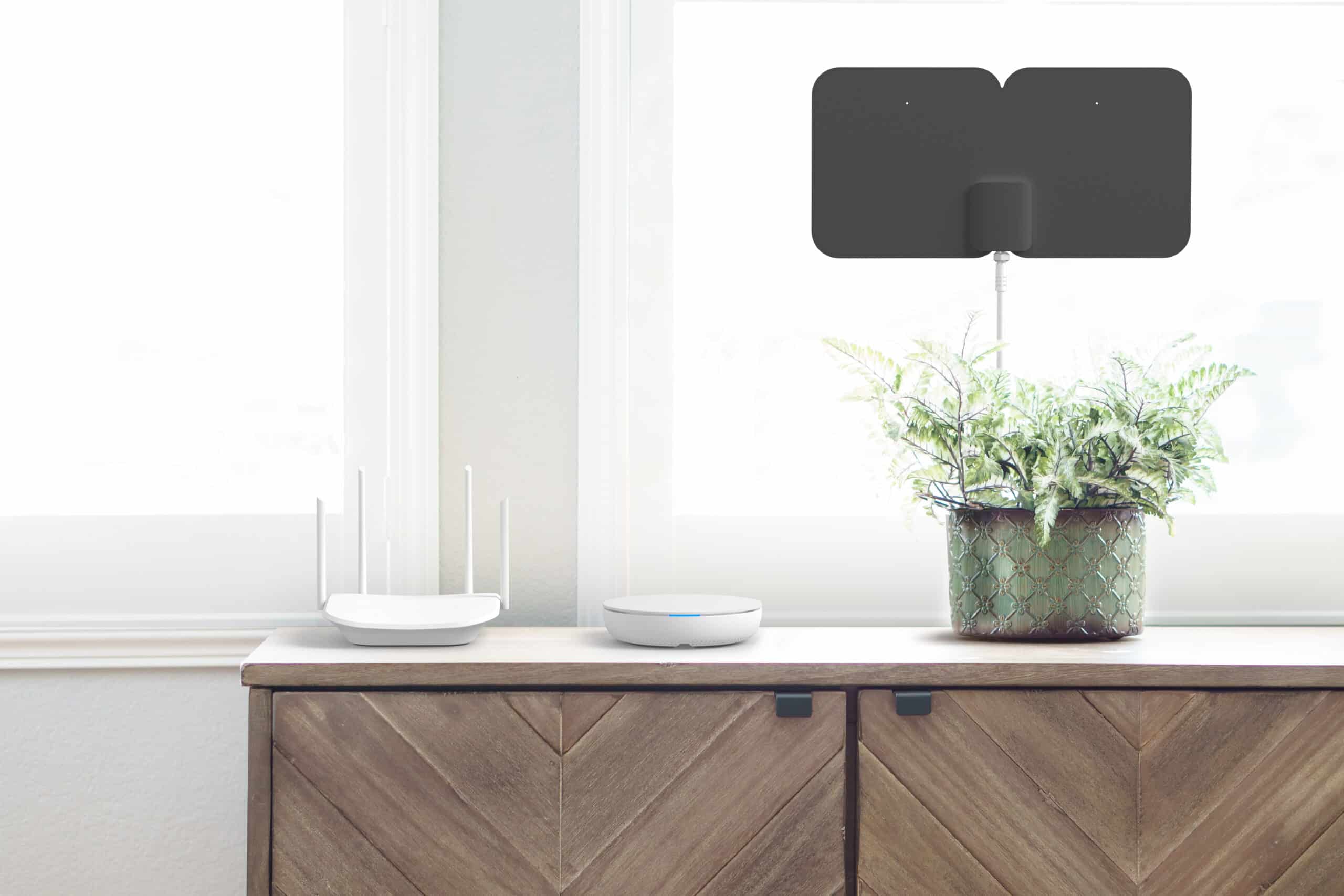 Tablo near router on wooden credenza with black antenna in window behind