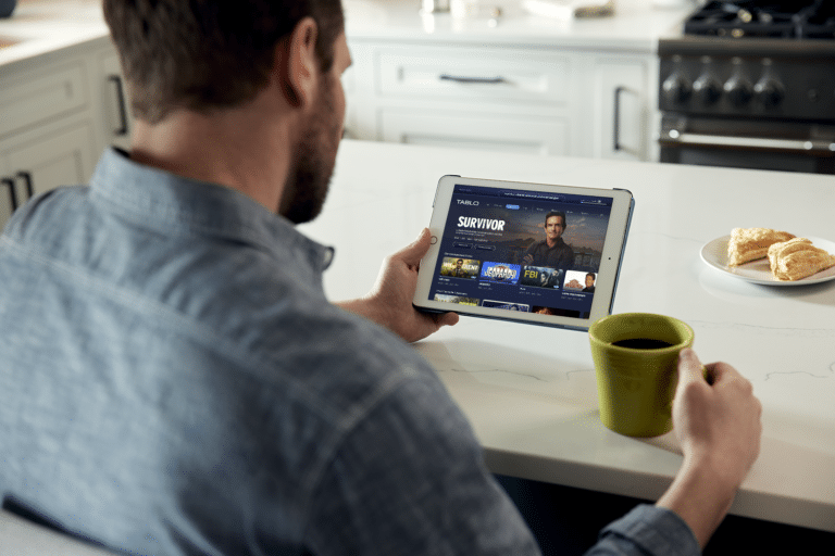 Man in kitchen using Tablo app on his tablet