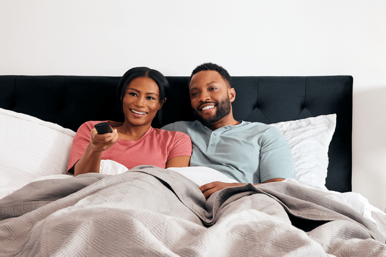 Couple in bed watching TV