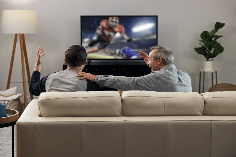 Older man and younger man watching football
