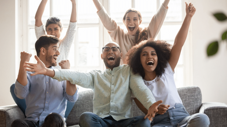 Group of men and women cheering on a couch