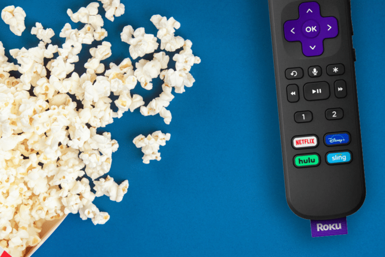 Roku remote on blue background next to popcorn